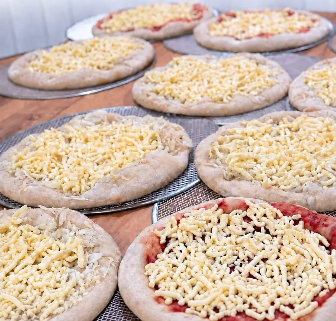 Pizzas listas sobre la mesa de trabajo